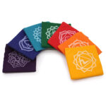 Chakra coloured square mats with chakra symbols arranged in a curved display.