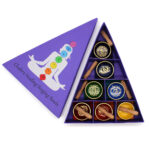 Opened pyramid shaped 7 chakra singing bowl gift set, showing contents and full colour printed lid.